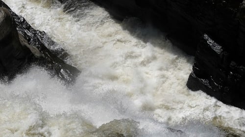 Cascada que golpea y salpica sobre la superficie de rocas duras,