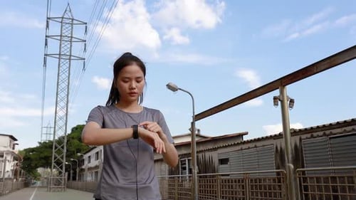 Young Woman Using Smart Watch in Urban Setting