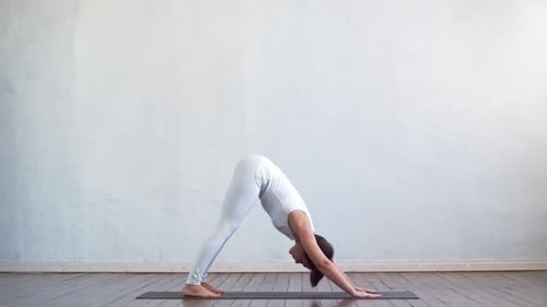 Woman Practicing Yoga on Mat in Bright Room