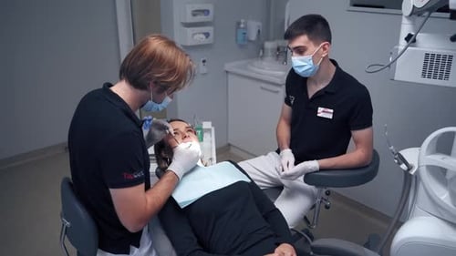 Dentist at work in clinic. Woman at the dentist while treatment process at the dental clinic
