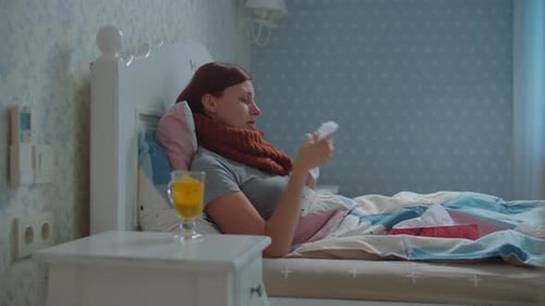 Jeune femme malade allongée dans son lit fatiguée de couler le nez. Dame avec une écharpe chaude sur le cou, toux et coups