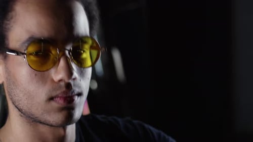 Young Adult with Glasses Posing near Neon Lights