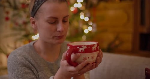 Woman Enjoying Christmas Drink by Christmas Tree