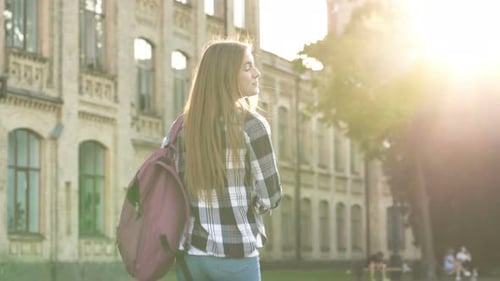 Aluna caminhando no parque para o prédio da faculdade