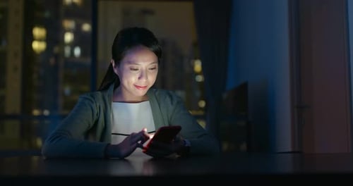 Woman Using Mobile Phone At Night In City