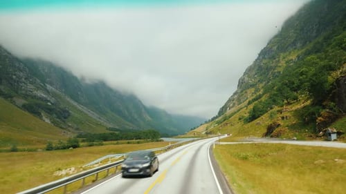 Scenic Road Among the Mountains in Norway. View From the Window of a Traveling Car