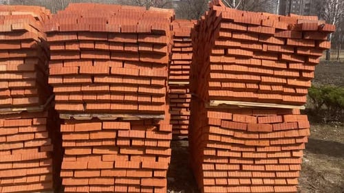Pile of Pallets with Red Bricks on City Street