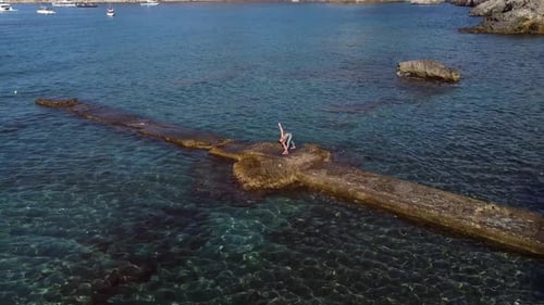 Femme méconnaissable faisant du yoga au bord de la mer