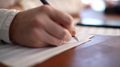 Hand Writing Music on Sheet Music Close Up