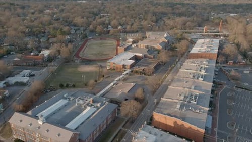 Establishing shot of Durham neighborhood and soccer field in background in North Carolina, USA. Aeri