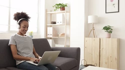 Woman Using Laptop Computer on Couch at Home