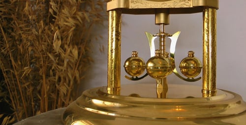 Swinging Pendulum of an Antique Golden Clock