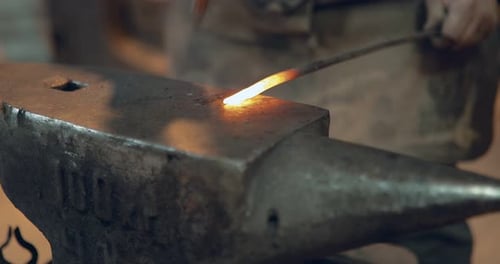 Blacksmith Shaping Red Hot Metal on Anvil