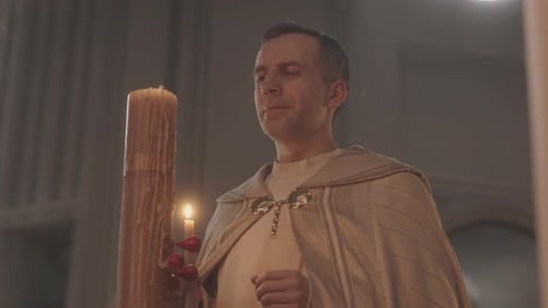 Priest Lighting Candle in Catholic Church