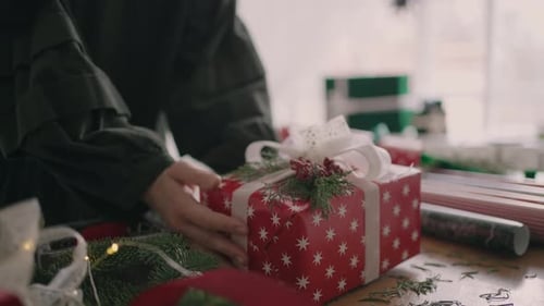Woman Wrapping a Holiday Gift with Red Star Paper