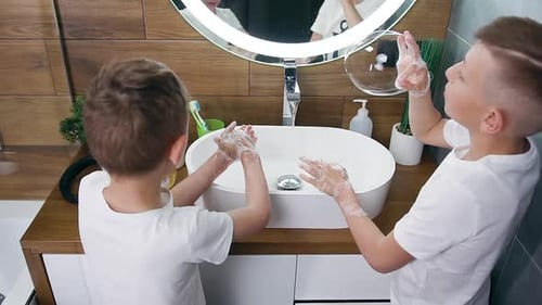 Young Boys Wash Hands in Modern Bathroom