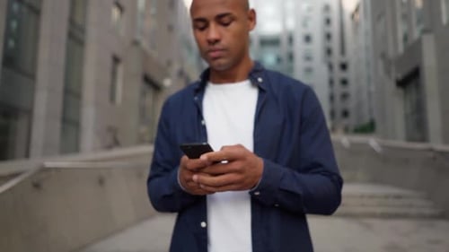 Man Uses Smartphone in Urban Downtown Setting