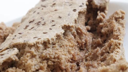 Close-up tilting over rustic bread crust with full healthy grain and barley 4K 2160p 30fps UltraHD