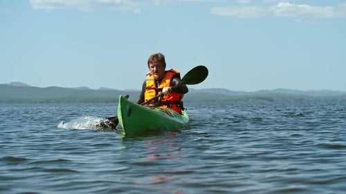 Man Paddling Kayak on Tropical Lake Adventure