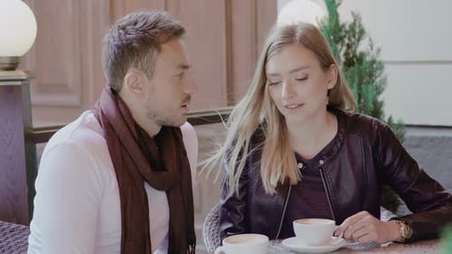 Couple Drinking Coffee On Date At Cafe Outdoors