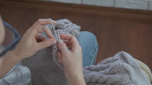 Woman Knitting a Sweater Indoors Close-Up