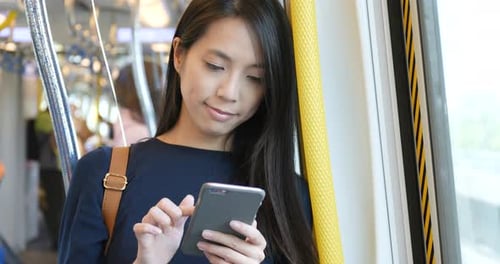 Young Woman Uses Smartphone on a Train