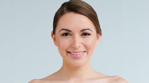 Close Up of Smiling Woman Against Gray Backdrop