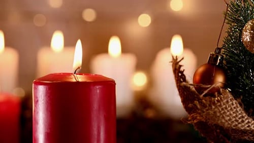 Close Up Shot of a Christmas Burning Candle on Bokeh Background