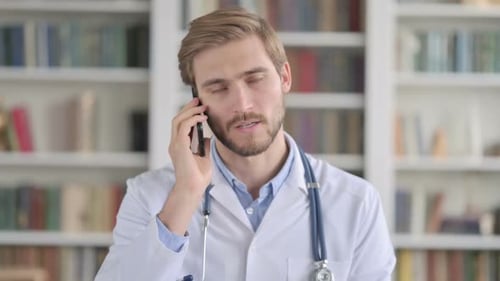 Doctor Talking on Smartphone in Front of Bookshelf