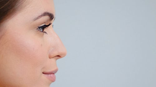 Side View on Beautiful Woman Face Posing Over Gray