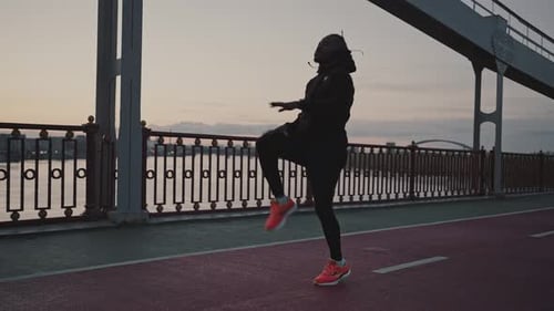 Sporty African American Guy Warming Up and Start Run Workout on City Bridge Training in Evening