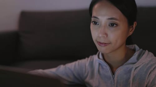 Woman Working on Laptop Computer at Night