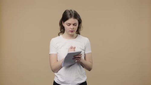 Woman Thinking and Writing in Notebook