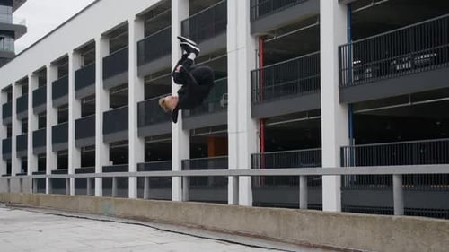 Young Man Does Flips and Jumps Parkour on Modern City Free Running in Slow Motion