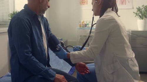 Therapist Checking Pressure Patient in Clinic Close Up