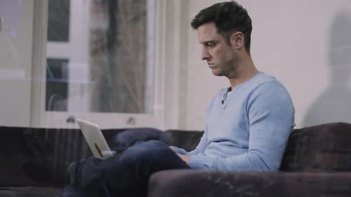Man Using Laptop While Sitting on Couch