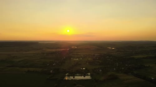 Aerial Landscape View of Green Cultivated Agricultural Fields with Growing Crops and Distant Village
