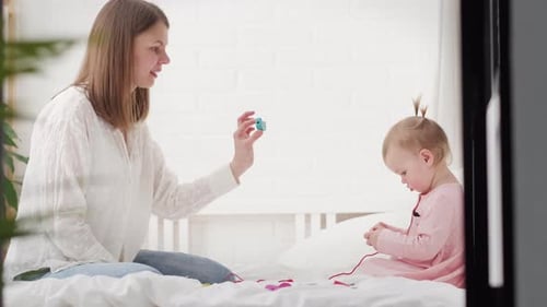 Mother and Baby Playing Together in Bedroom