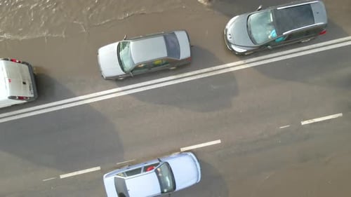 Aerial View of City Traffic with Cars Driving on Flooded Street After Heavy Rain