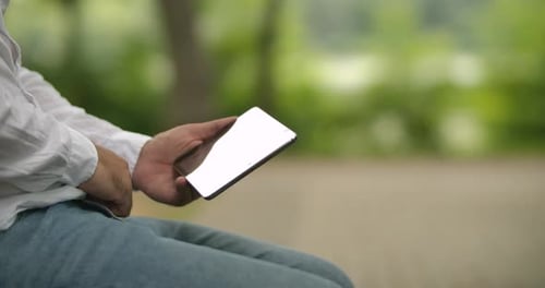 Man Uses Tablet Computer in Green Park