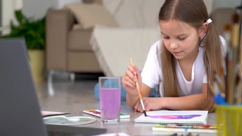 Girl Painting a Watercolor on Floor at Home