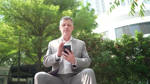 Man Using Smartphone in Urban Green Space