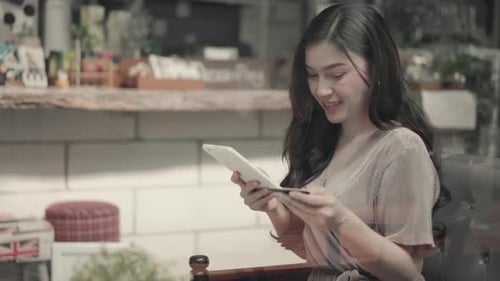 Woman Using Tablet and Credit Card in Cafe
