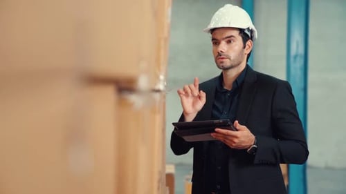 Directeur d'usine utilisant une tablette informatique dans un entrepôt ou une usine