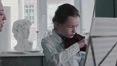 Girl Practices Violin with Teacher at Home