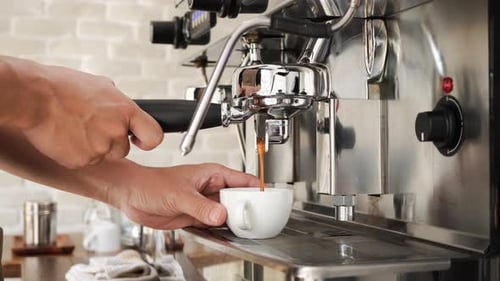 Barista brewing fresh coffee into the cup with machine in cafe - dolly shot