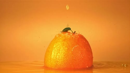 Super Slow Motion on a Ripe Orange Drops a Drop of Juice