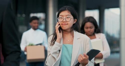 Young Beautiful Office Worker with Glasses Finishes Work Goes Outside in Front of Company Building