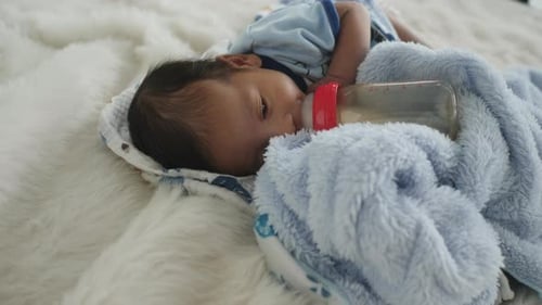 El recién nacido está tomando leche materna de un biberón, con una inyección a cámara lenta