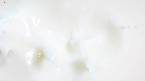 Trozos de fresa caen en la leche